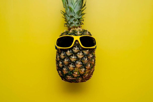 Piña en las gafas de sol sobre un fondo amarillo - Foto, Imagen