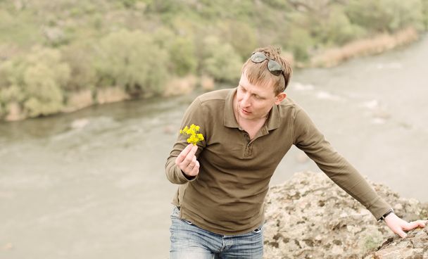 mężczyzna patrząc świeże kwiaty żółte - Zdjęcie, obraz