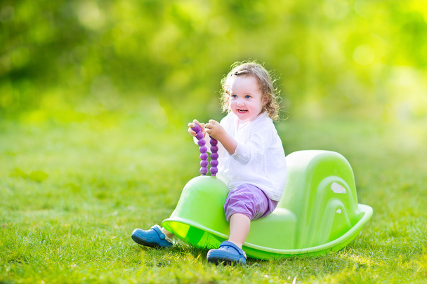 Toddler dziewczynka na huśtawce w ogrodzie - Zdjęcie, obraz