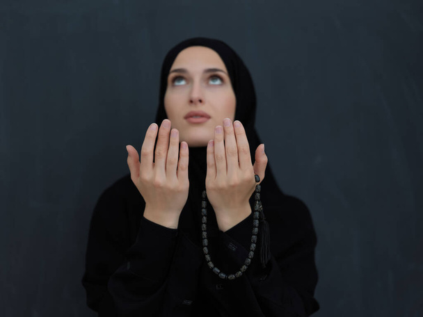 Portrait of young Muslim woman making dua. Arabian girl wearing abaya keeps hands in praying gesture. Representing worship to God and Ramadan Kareem concept - Photo, Image
