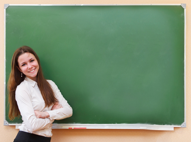 φοιτητής κορίτσι στέκεται κοντά σε μαυροπίνακα στην τάξη - Φωτογραφία, εικόνα