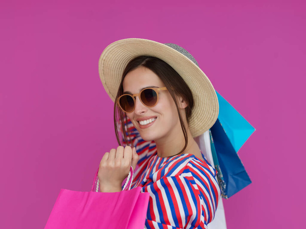 Young woman with shopping bags on pink background. Happy girl posing with new purchases after a day of big sale. Black Friday concept - Valokuva, kuva