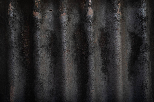 A chapa de aço ondulada de zinco velha preta tem ferrugem na textura. - Foto, Imagem