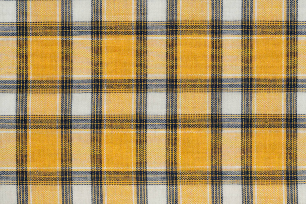 Жёлтый белый фактурный фон тартана. ткань рубашки с клетчатым рисунком. фабричный материал - Фото, изображение