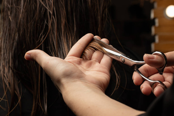 Une coupe de cheveux de femme dans un gros plan de salon de coiffure. Coiffeur, ciseaux, cheveux, outil, soins, mouillé, mains du maître - Photo, image
