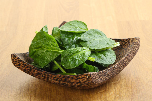 Свіжі зелені листя шпинату в мисці на дерев'яному фоні
 - Фото, зображення