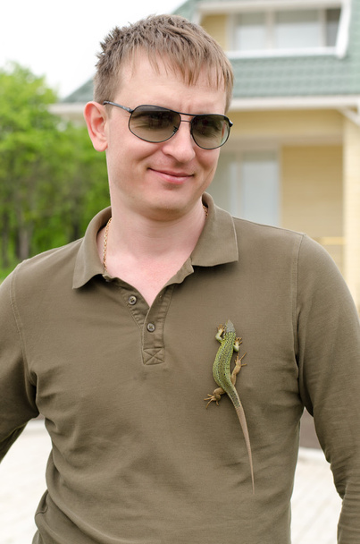 Красивый мужчина, позирующий с ящерицей на рубашке.
 - Фото, изображение