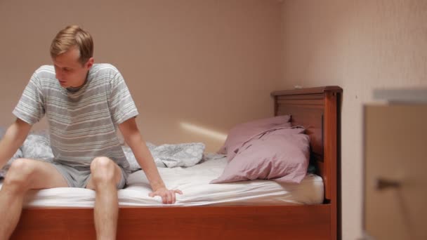Nemocný muž sedí na posteli - Záběry, video