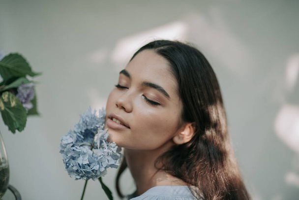 beautiful girl posing with hydrangea flowers  - Foto, Imagen