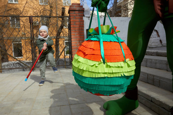 Persona de la cosecha de pie con piñata durante la fiesta - Foto, Imagen