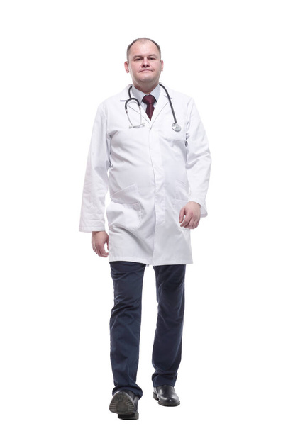 qualified male paramedic striding forward . isolated on a white - Foto, afbeelding