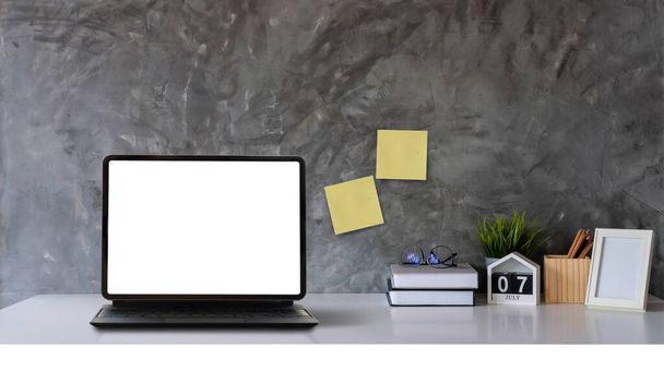Çalışma alanı tablet bilgisayarında beyaz boşluk, kitaplar ve ahşap masa üzerinde ahşap tavan arası duvarı olan bir tencere.. - Fotoğraf, Görsel
