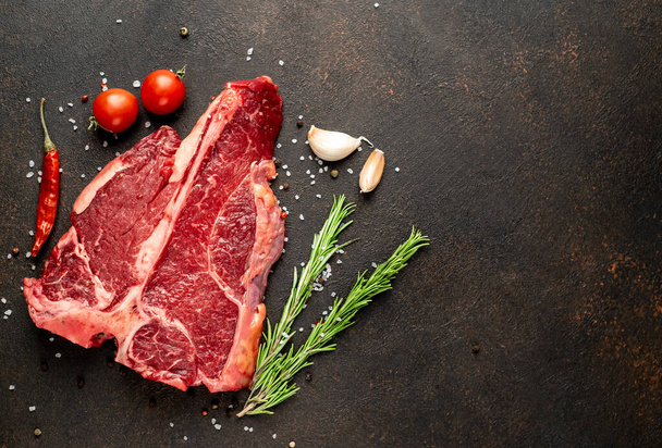 friss nyers marhahús, fokhagyma, só és bors, fekete háttér, felülnézet, rezsi - Fotó, kép