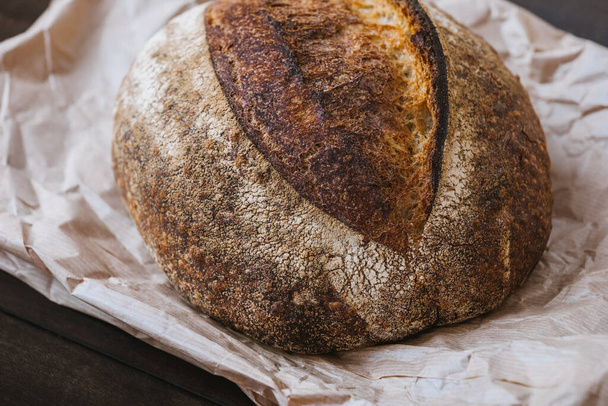Close-up hot rye circle bread with crispy crust on a craft package - Фото, зображення