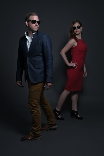 Couple de mode portant une robe rouge, lunettes de soleil noires et ja bleu
 - Photo, image