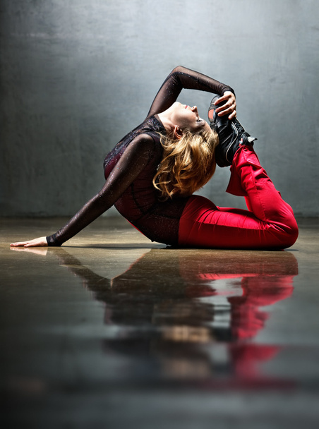 Young sports woman stretching on floor. - 写真・画像