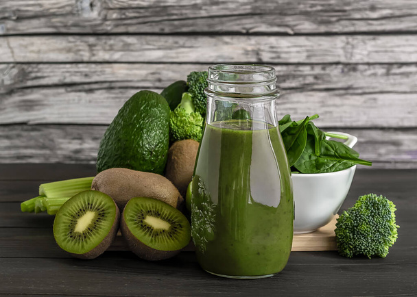 Fresh green vegetables and smoothie on wooden background  - Photo, Image