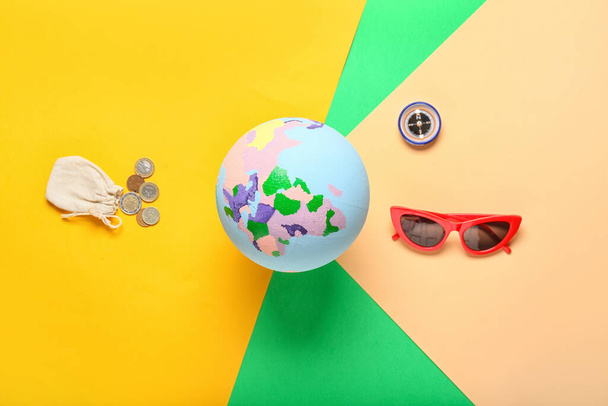 Globe s mincemi, kompas a sluneční brýle na barevném pozadí - Fotografie, Obrázek