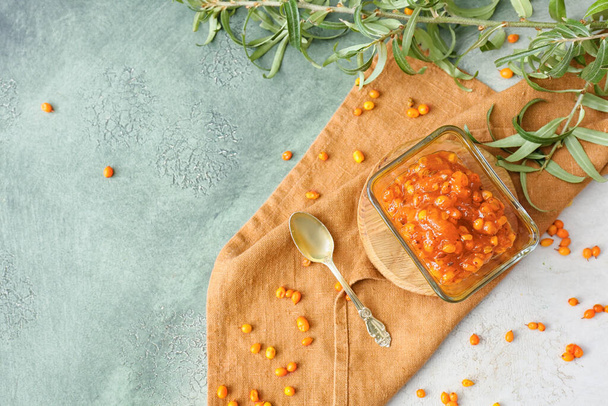 Bowl of healthy sea buckthorn jam on color background - Photo, Image