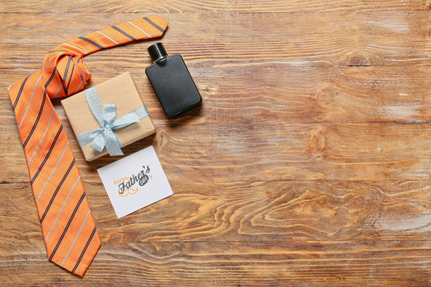 Greeting card for Father's Day with gift box and men's accessories on wooden background - Foto, Imagen