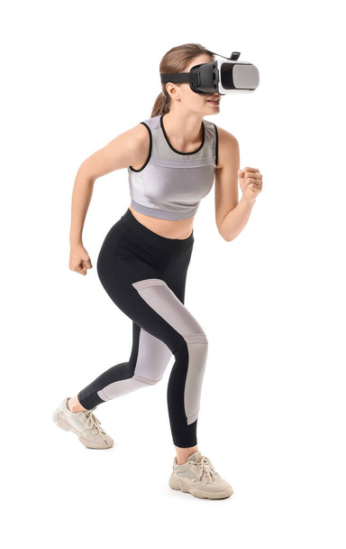 Sporty young woman with virtual reality glasses training on white background - Foto, afbeelding