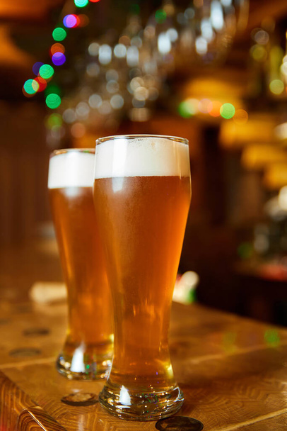 Dos vasos de cerveza espumosa fresca en el mostrador del bar - Foto, imagen