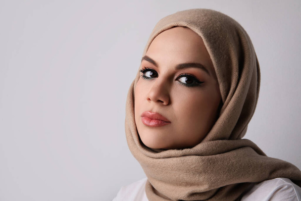 Close-up portrait of young muslim woman wearing beige hijab. Space for text. - Fotó, kép