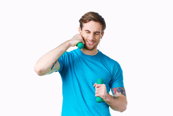 man with dumbbells in his hands blue t-shirt exercise fitness headphones - Fotó, kép