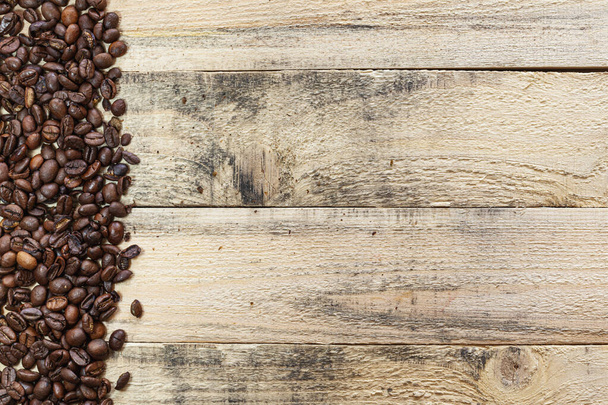 Textur oder Hintergrund aus mehreren Holzbrettern, die parallel zu einem Rand der Kaffeebohnen auf der linken Seite angeordnet sind. - Foto, Bild