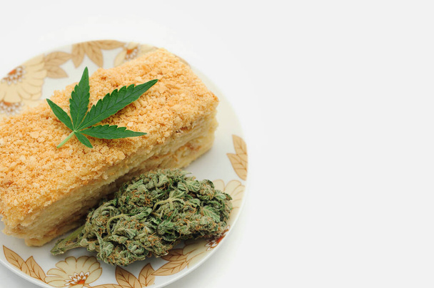 Blätterteigkuchen mit CBD-Öl und Cannabisblüten isoliert auf weißem Hintergrund. Marihuana-Küche, köstliches hausgemachtes Dessert.  - Foto, Bild