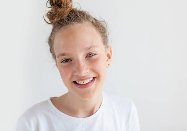 Portrait smiling young girl. Teen at white background - Fotó, kép
