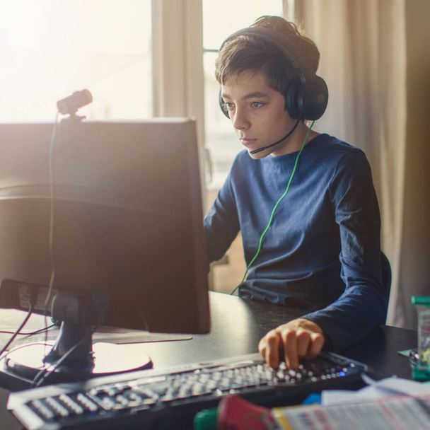 Teenager playing at computer game. Boy at home - Фото, изображение