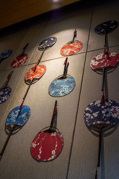 Ściany pokryte są japońskimi papierowymi okrągłymi wentylatorami - Zdjęcie, obraz