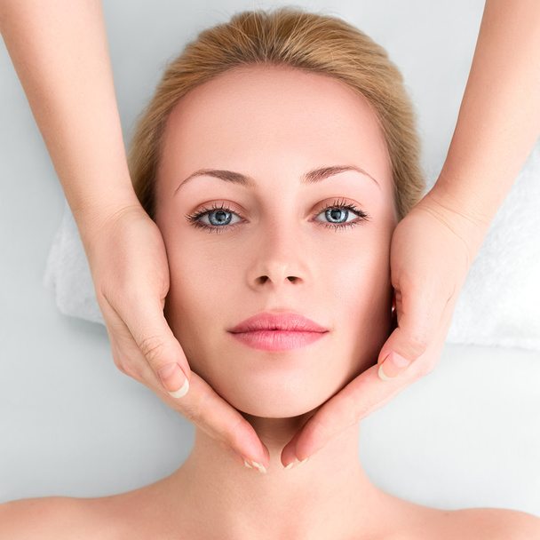 Jovem mulher no spa recebe uma massagem facial
 - Foto, Imagem