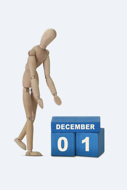 今月の日01 12月カレンダー青い立方体とその隣に立つ木製の男のカレンダーの日付。白地. - 写真・画像