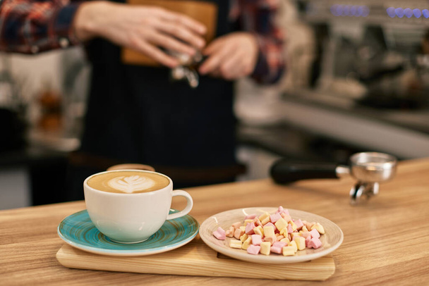 cup of hot drink and marshmallows on table in coffee shop - Foto, Imagem