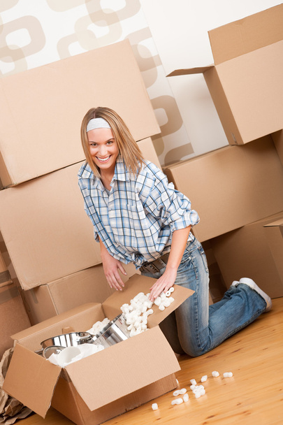 Moving house: Happy woman unpacking box - Foto, Bild