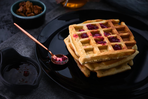 waffles with honey on a dark background, close-up - Φωτογραφία, εικόνα