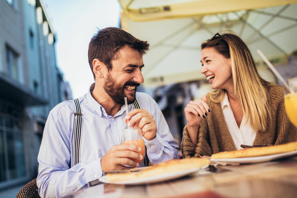 Egy fiatal boldog pár pizzát eszik ebédre egy étteremben. - Fotó, kép