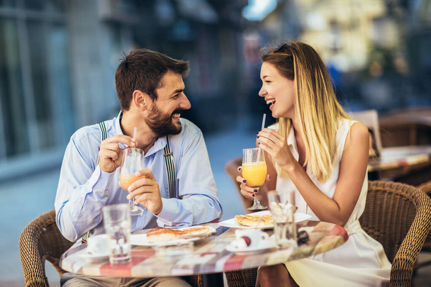 若い幸せなカップルは、レストランで昼食のためのピザを食べる - 写真・画像