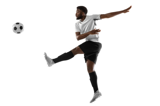 Young African football soccer player training isolated on white background. Concept of sport, movement, energy and dynamic. - Foto, Bild
