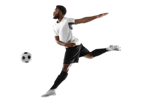 Young African football soccer player training isolated on white background. Concept of sport, movement, energy and dynamic. - Zdjęcie, obraz