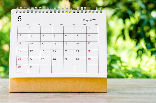 Maj 2021 Kalendarz biurko dla organizatora zaplanować i przypomnieć na drewnianym stole na tle natury. - Zdjęcie, obraz