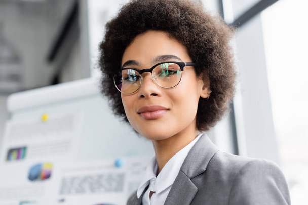 African american businesswoman in eyeglasses looking at camera in office  - Foto, Imagen