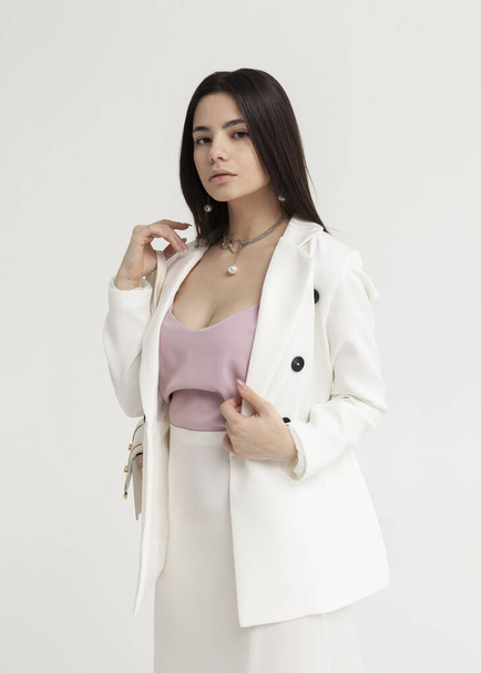 beautiful brunette in a white summer suit with a bag in her hands - Foto, immagini