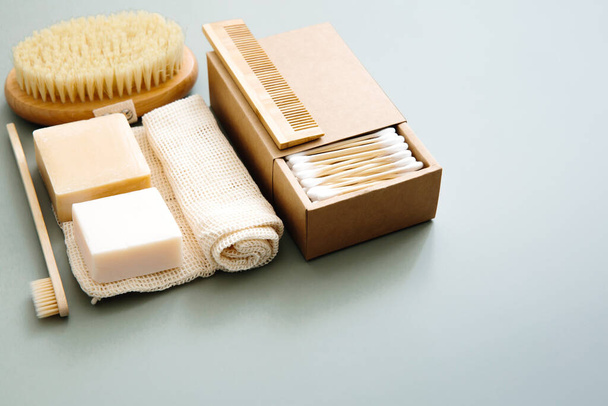 Eco-friendly lifestyle, plastic free. Natural bathroom accessories: organic soap, natural brush, bamboo ear sticks, reusable cotton bags on green background. - Photo, Image