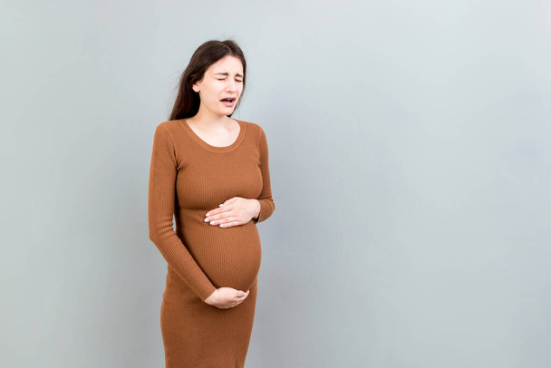 Сумна і напружена вагітна жінка ізольована на кольоровому фоні
. - Фото, зображення