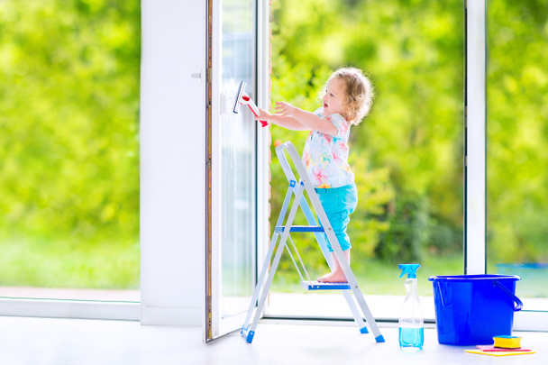Little girl washing a window - Photo, Image