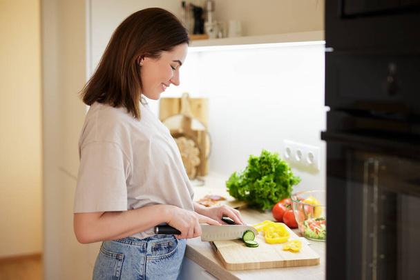 Sağlıklı gıda kavramı - kadın modern mutfakta taze salata pişiriyor - Fotoğraf, Görsel