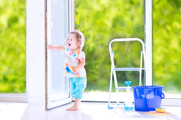 Маленька дівчинка миє вікно
 - Фото, зображення